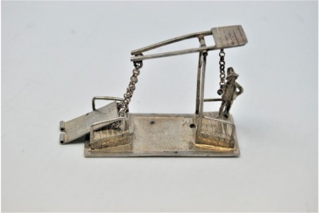 Figura de portageiro em prata e ponte levadiça.